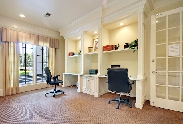 carpeted office space featuring built in desk and ornamental molding