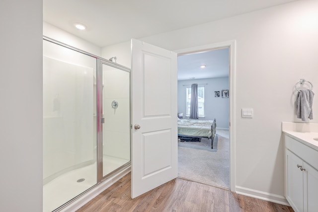 bathroom featuring an enclosed shower, vanity, and hardwood / wood-style flooring