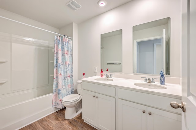 full bathroom featuring shower / bath combination with curtain, hardwood / wood-style floors, vanity, and toilet