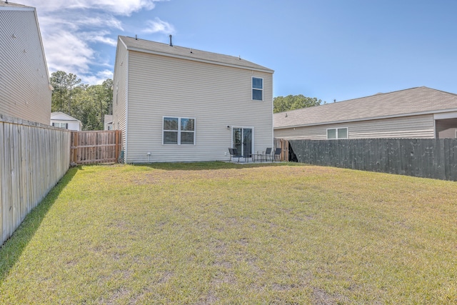 rear view of property with a yard