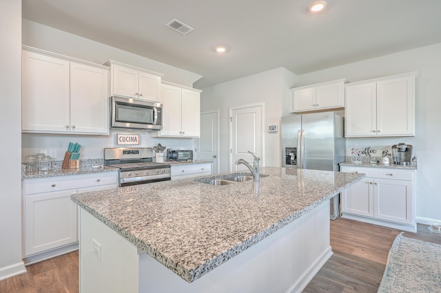 kitchen with a kitchen island with sink, appliances with stainless steel finishes, dark wood-type flooring, and white cabinetry