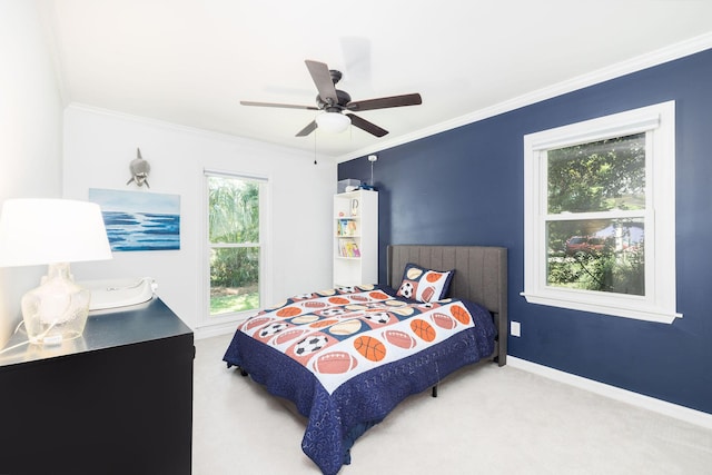 carpeted bedroom with baseboards, ceiling fan, and crown molding