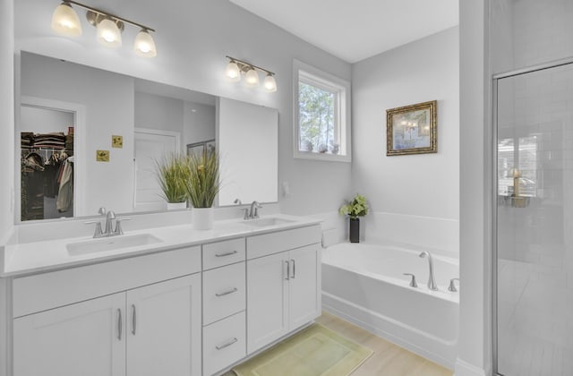 bathroom with vanity and shower with separate bathtub