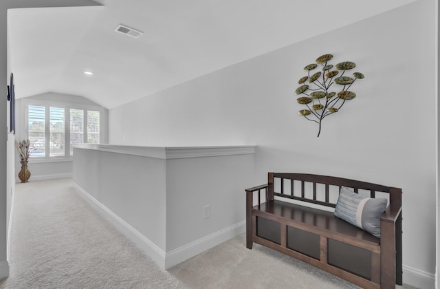 corridor with light colored carpet and lofted ceiling