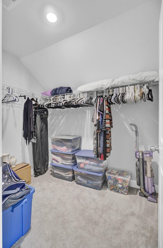 spacious closet with vaulted ceiling and carpet flooring