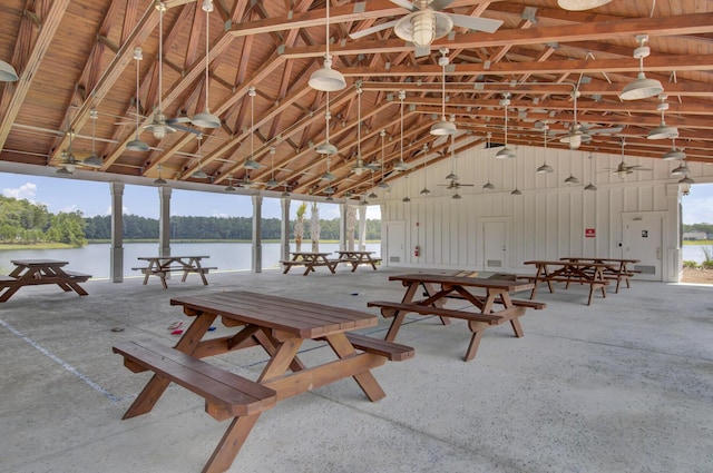 interior space with a water view, high vaulted ceiling, and ceiling fan