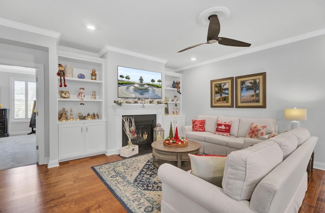 living room featuring crown molding, wood-type flooring, built in features, and ceiling fan