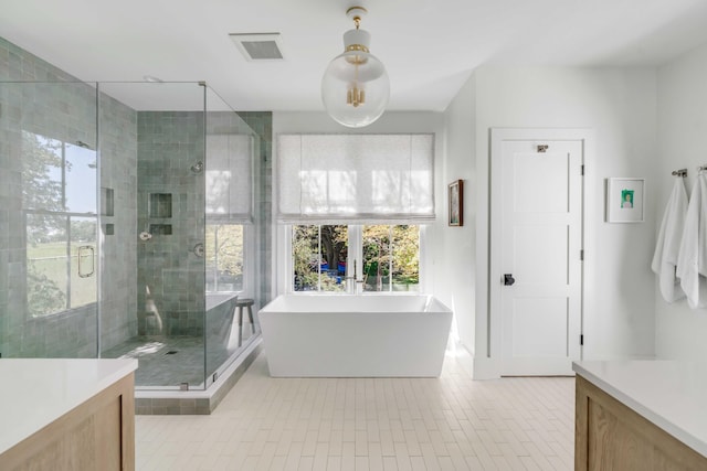 bathroom with tile patterned flooring, vanity, and shower with separate bathtub