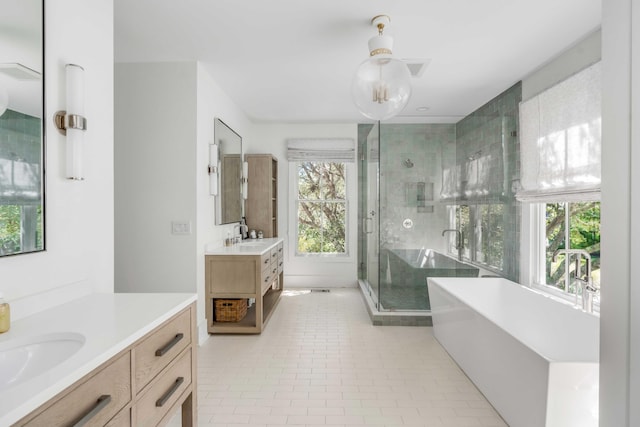 bathroom with tile patterned flooring, vanity, a healthy amount of sunlight, and shower with separate bathtub