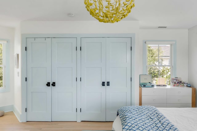 bedroom with light wood-type flooring and two closets