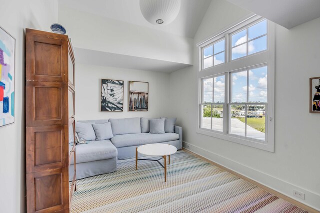 living room featuring a healthy amount of sunlight, carpet, and high vaulted ceiling