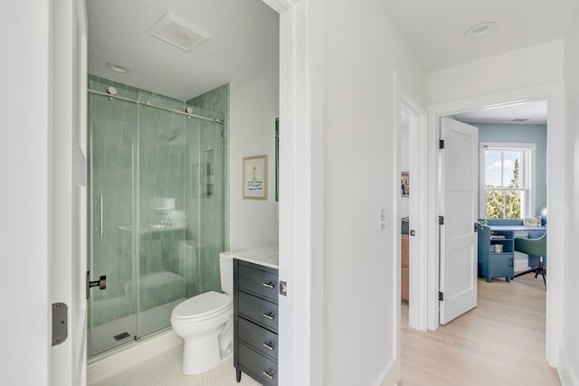 bathroom with vanity, toilet, an enclosed shower, and wood-type flooring