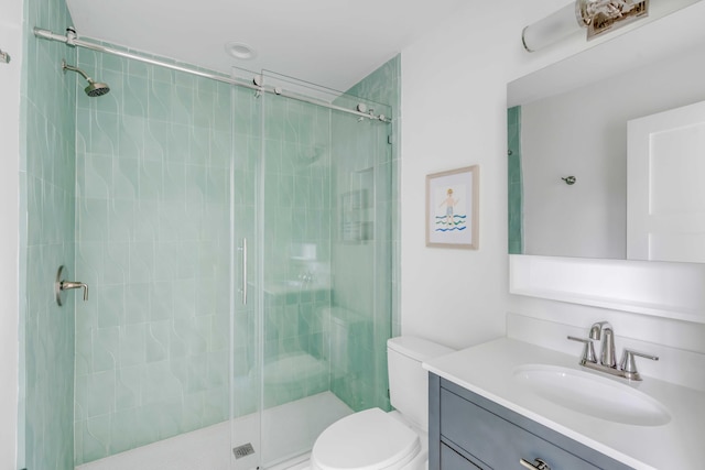 bathroom featuring vanity, toilet, and a shower with door