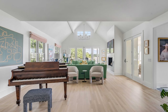 misc room with light wood-type flooring, a wealth of natural light, an inviting chandelier, and french doors