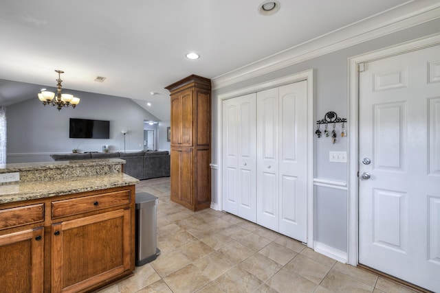 kitchen featuring brown cabinetry, lofted ceiling, recessed lighting, a chandelier, and decorative light fixtures