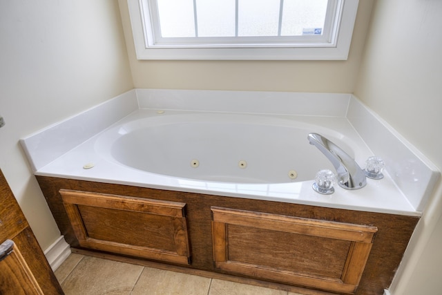 bathroom with tile patterned floors and a tub with jets