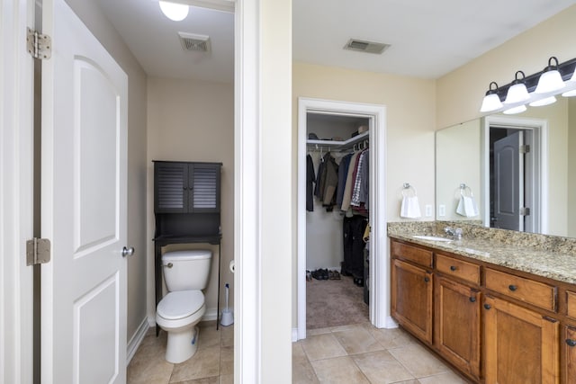 full bathroom with toilet, tile patterned floors, visible vents, and vanity