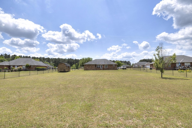 view of yard featuring fence, an outbuilding, and a carport