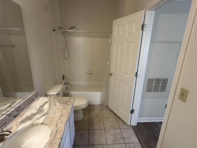 full bathroom with vanity, tiled shower / bath, tile patterned floors, and toilet