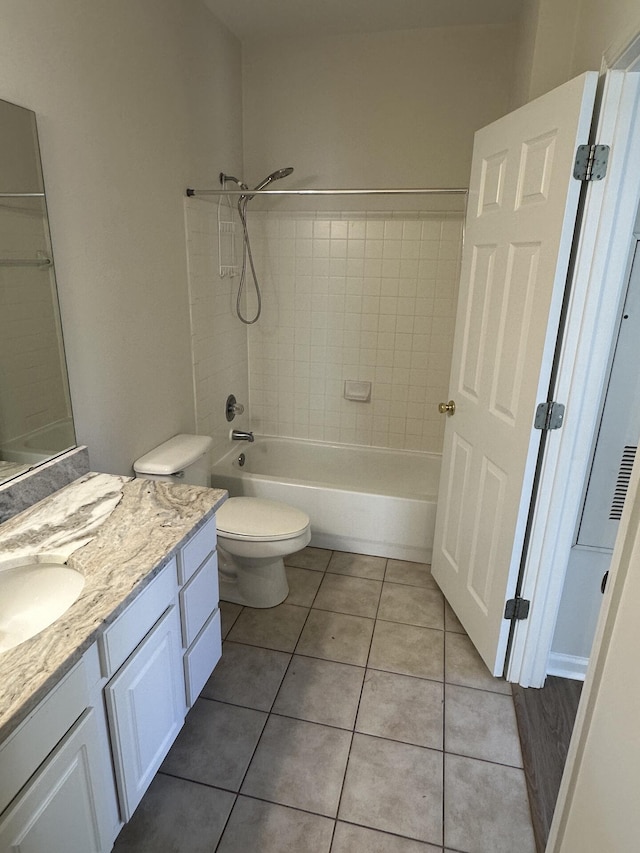 full bathroom with vanity, tiled shower / bath, tile patterned floors, and toilet