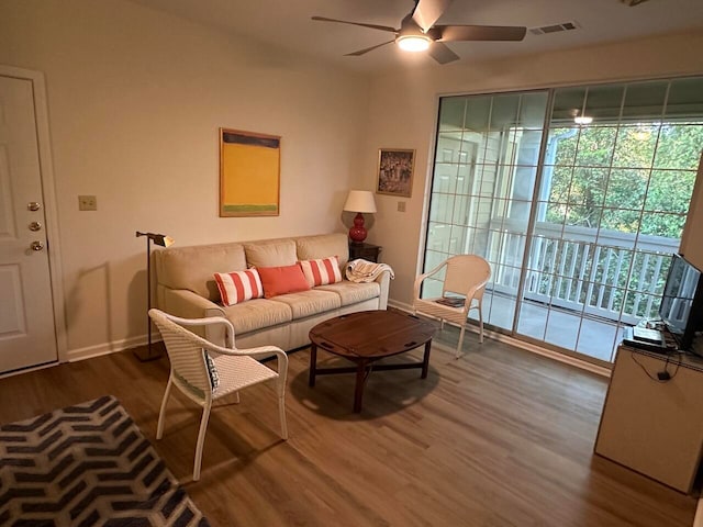 living room featuring dark hardwood / wood-style flooring and ceiling fan