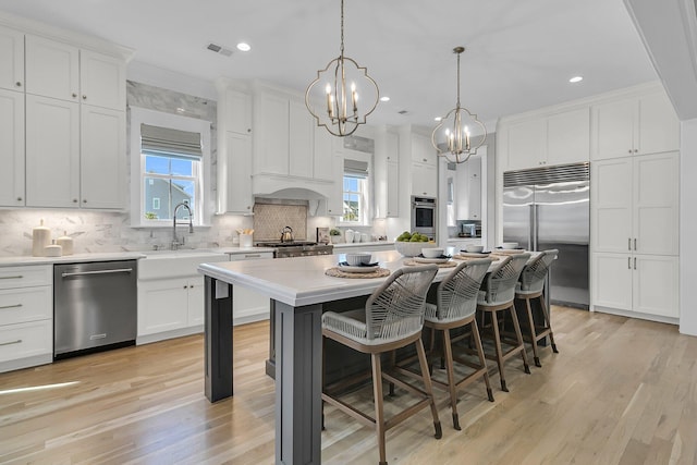 kitchen featuring tasteful backsplash, appliances with stainless steel finishes, a breakfast bar, and light countertops