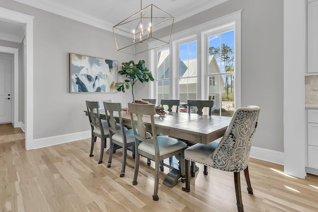 dining room with a chandelier, baseboards, light wood finished floors, and ornamental molding