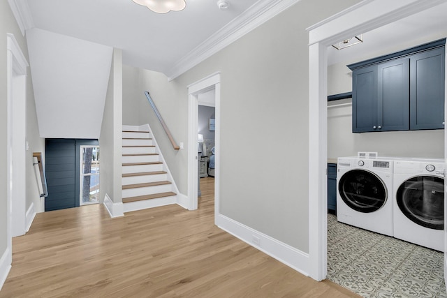 laundry area featuring baseboards, cabinet space, crown molding, and washing machine and clothes dryer