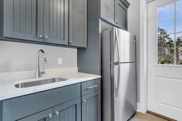 kitchen featuring gray cabinets and freestanding refrigerator