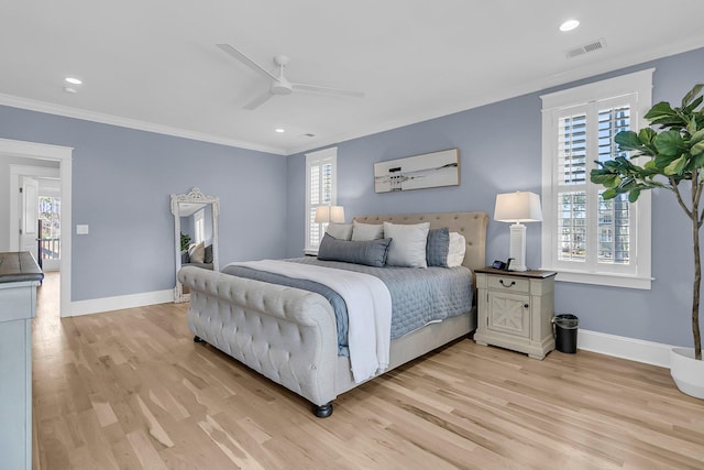 bedroom with light wood finished floors, visible vents, crown molding, and baseboards