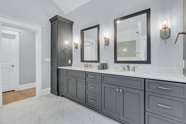 full bath featuring a sink, baseboards, marble finish floor, and double vanity