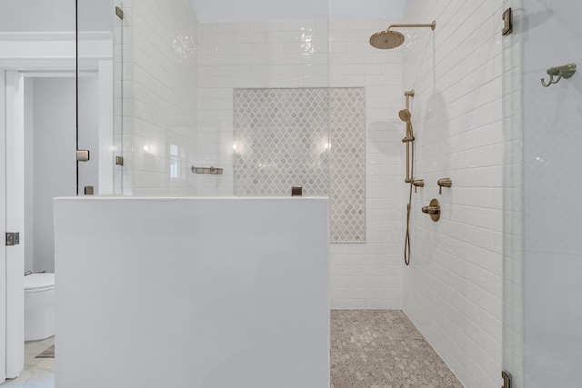 bathroom with toilet and tiled shower