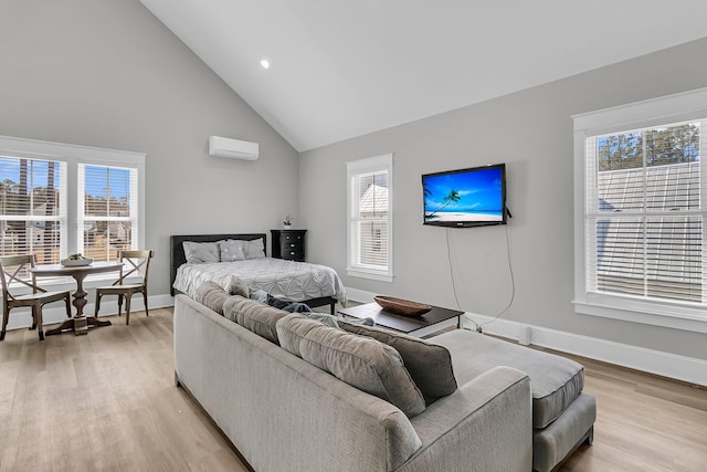 bedroom with an AC wall unit, baseboards, light wood-type flooring, and high vaulted ceiling