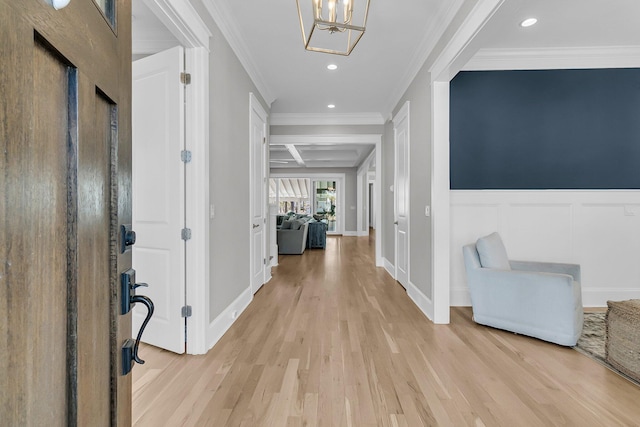 foyer entrance with recessed lighting, wainscoting, crown molding, and light wood-style floors