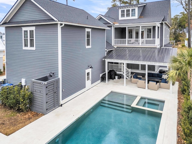 rear view of house featuring a shingled roof, an outdoor living space, a balcony, and a patio