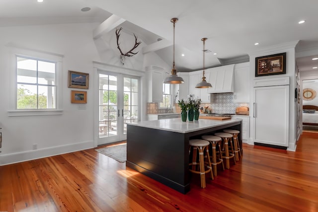 932 Middle St, Sullivans Island, SC 29482 - kitchen featuring decorative backsplash, a center island, white cabinetry, a breakfast bar area, and decorative light fixtures