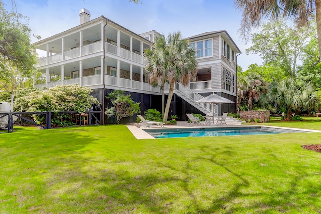 932 Middle St, Sullivans Island, SC 29482 - rear view of property with a chimney, a yard, an outdoor pool, stairs, and a patio