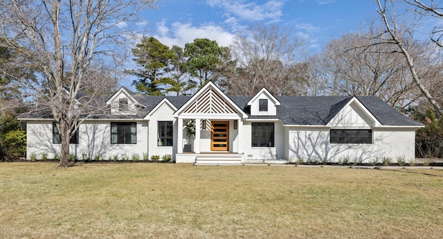 modern farmhouse with a front yard and brick siding