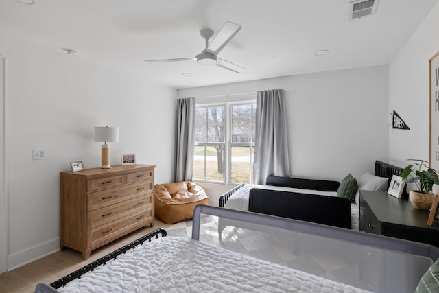 bedroom featuring light wood finished floors, ceiling fan, visible vents, and baseboards