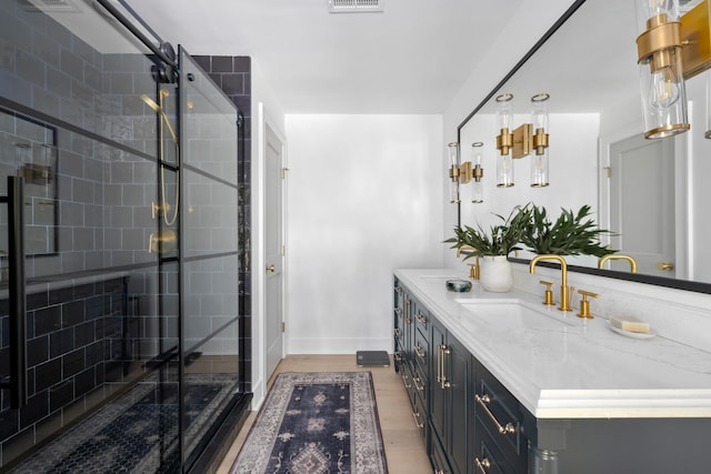 bathroom with wood finished floors, visible vents, vanity, baseboards, and a shower stall