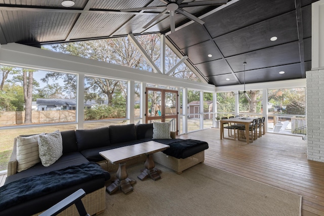 sunroom / solarium featuring vaulted ceiling with beams