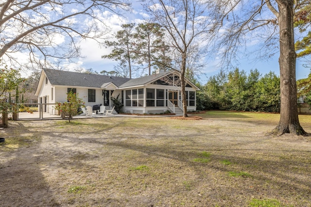 back of property featuring a sunroom, a patio area, and a yard