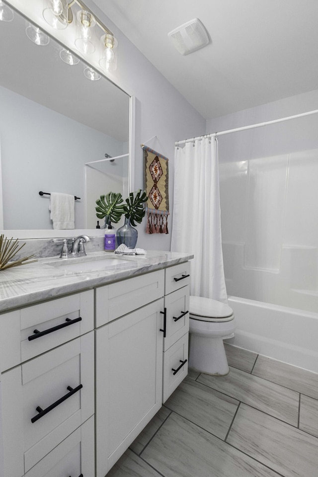 bathroom with visible vents, toilet, vanity, and shower / bath combo