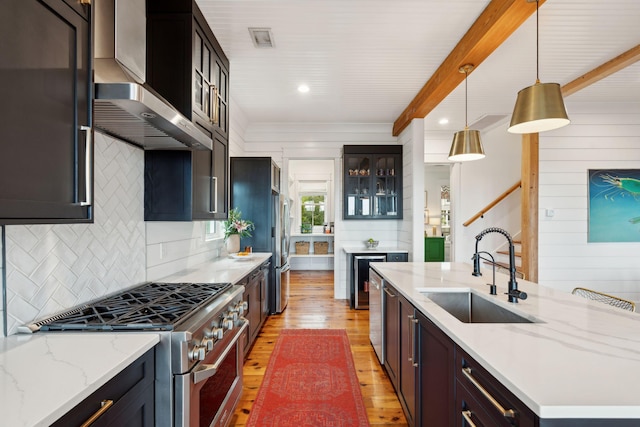 1809 Rushland Grove Ln, Johns Island, SC 29455 - kitchen featuring stainless steel appliances, light wood-type flooring, wall chimney exhaust hood, decorative backsplash, and glass insert cabinets