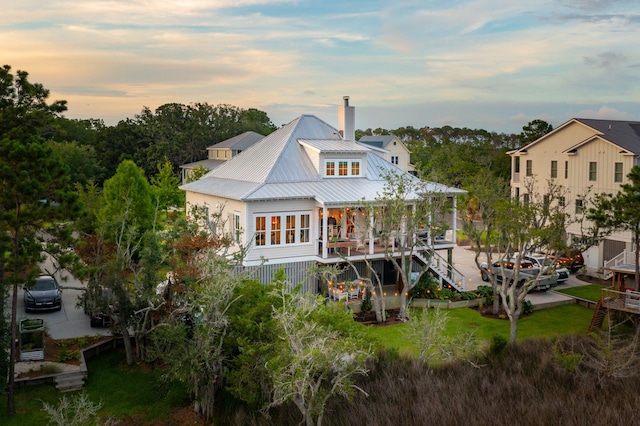 1809 Rushland Grove Ln, Johns Island, SC 29455 - rear view of house featuring a chimney, a porch, a metal roof, and stairs