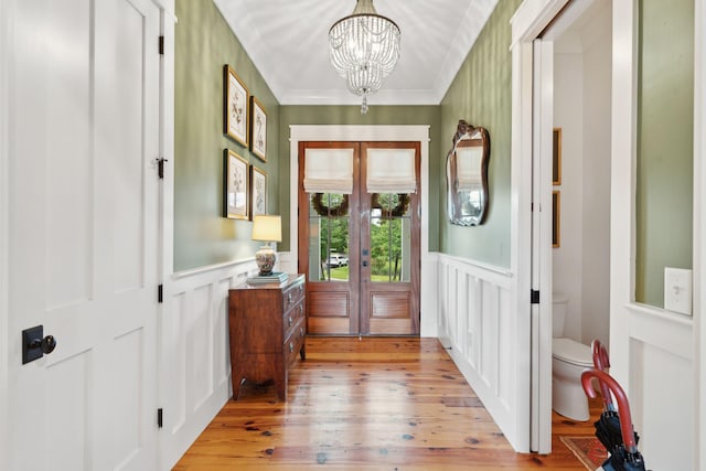 1809 Rushland Grove Ln, Johns Island, SC 29455 - foyer with french doors, a chandelier, wainscoting, light wood-type flooring, and a decorative wall