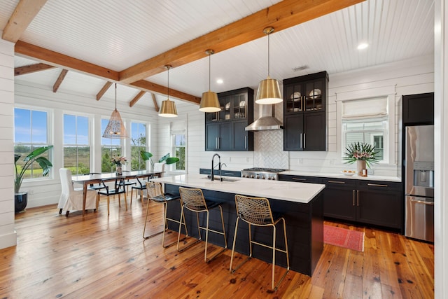 1809 Rushland Grove Ln, Johns Island, SC 29455 - kitchen with stainless steel fridge, a breakfast bar, light countertops, beamed ceiling, and wall chimney exhaust hood