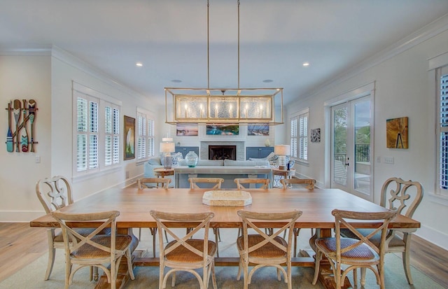 dining space with hardwood / wood-style flooring, a healthy amount of sunlight, and ornamental molding