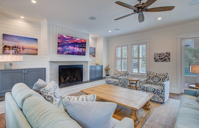 living room with ceiling fan, light wood-type flooring, and crown molding