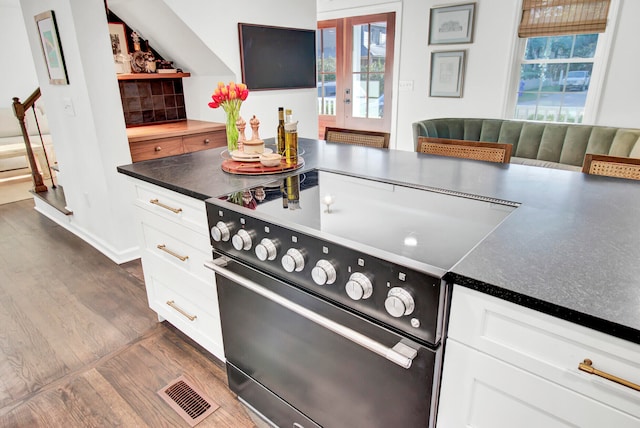 kitchen with white cabinets, french doors, dark hardwood / wood-style floors, and high end stainless steel range